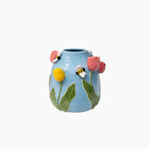 Decorative vase with floral and bee designs on a white background