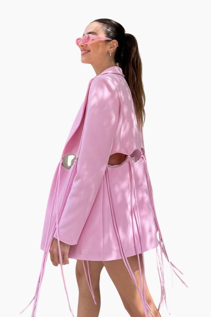 model wearing a pink blazer over a white outfit 