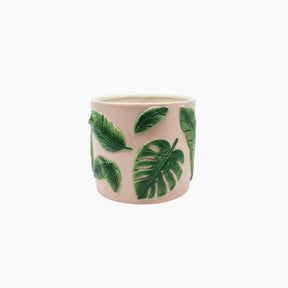 Ceramic mug with green leaf patterns on a white background