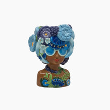 Decorative figurine of a woman with a floral headpiece and sunglasses on a white background