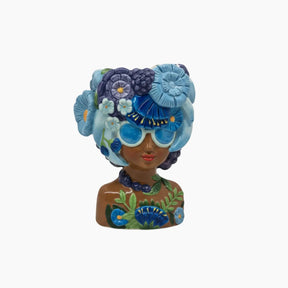 Decorative figurine of a woman with a floral headpiece and sunglasses on a white background