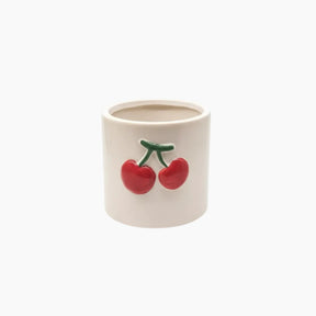 Ceramic container with red cherries on a white background