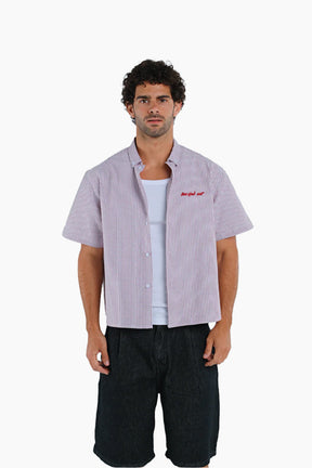 Man wearing a checkered shirt over a white t-shirt with text