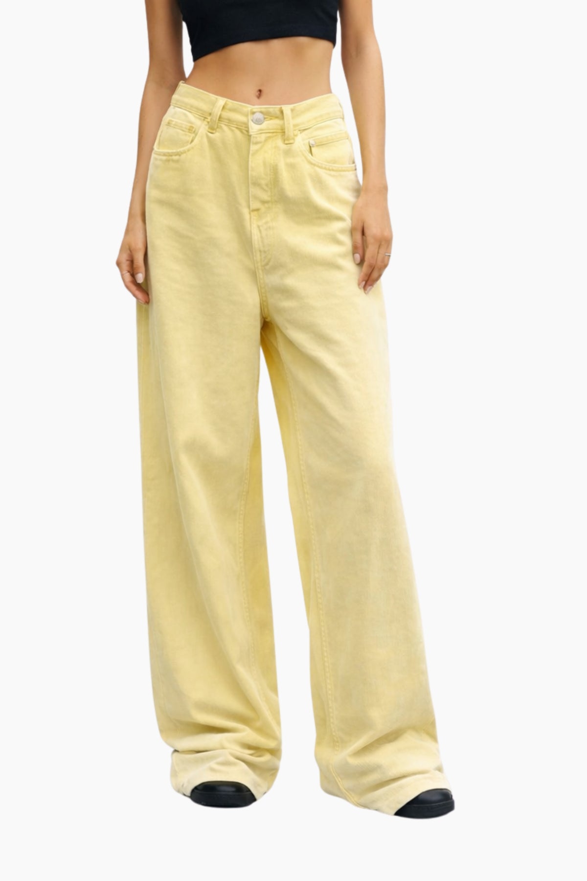 Person wearing light yellow wide-leg pants on a white background