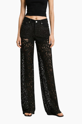 Black lace pants worn by a model on a white background