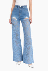 Light blue jeans with distressed details worn by a person on a white background