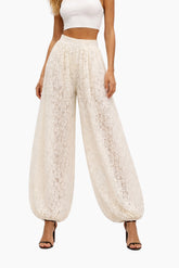 White lace pants worn by a person on a white background