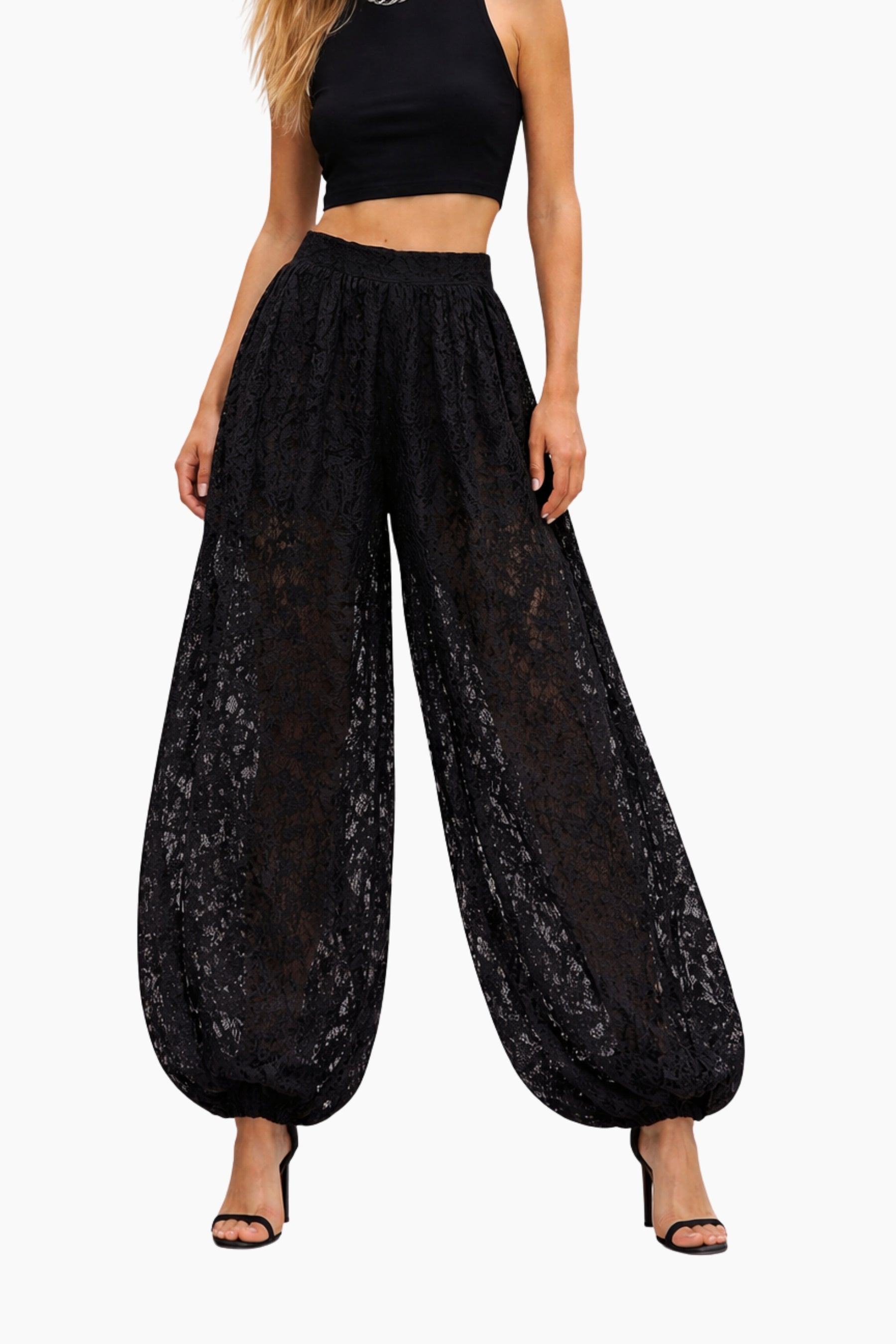 Black lace pants worn by a model on a white background
