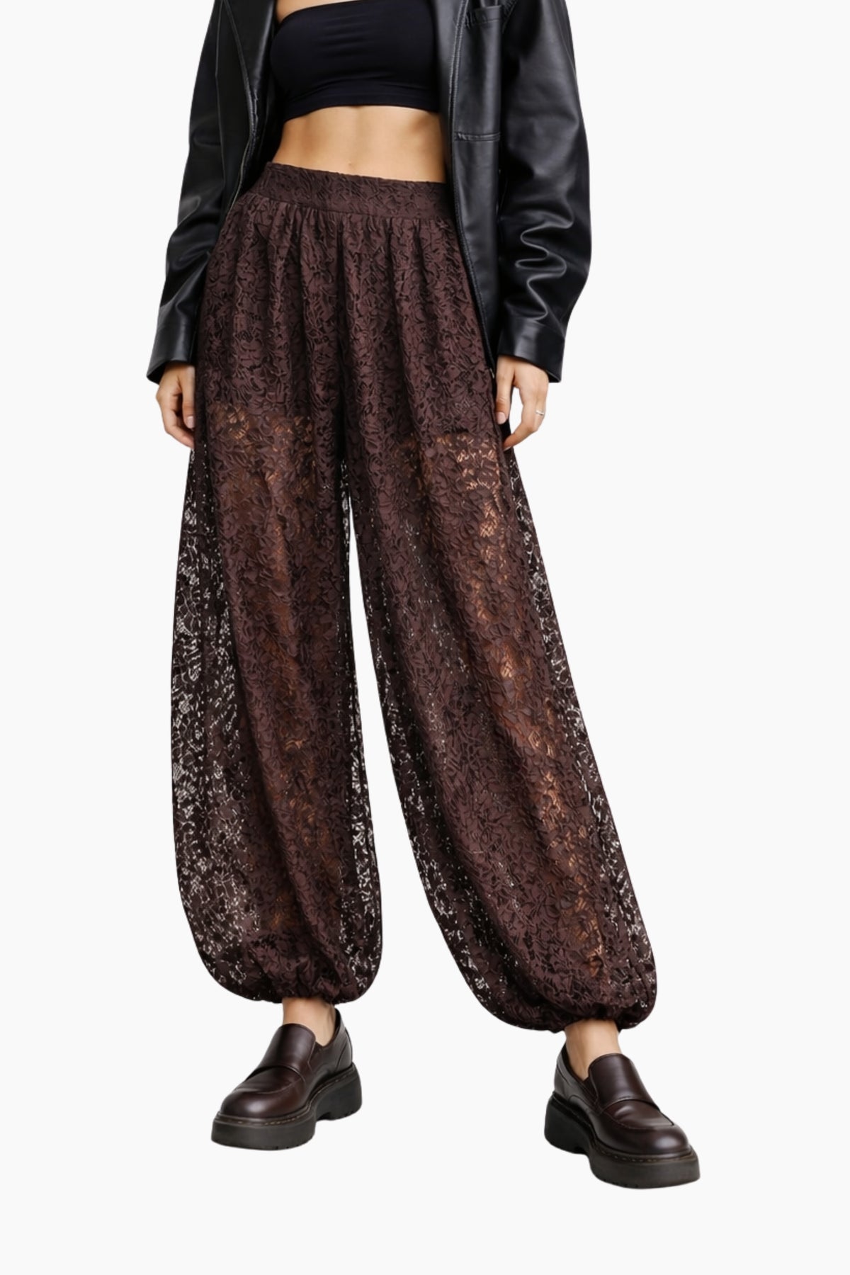 Person wearing brown lace pants with a black top and leather jacket on a white background