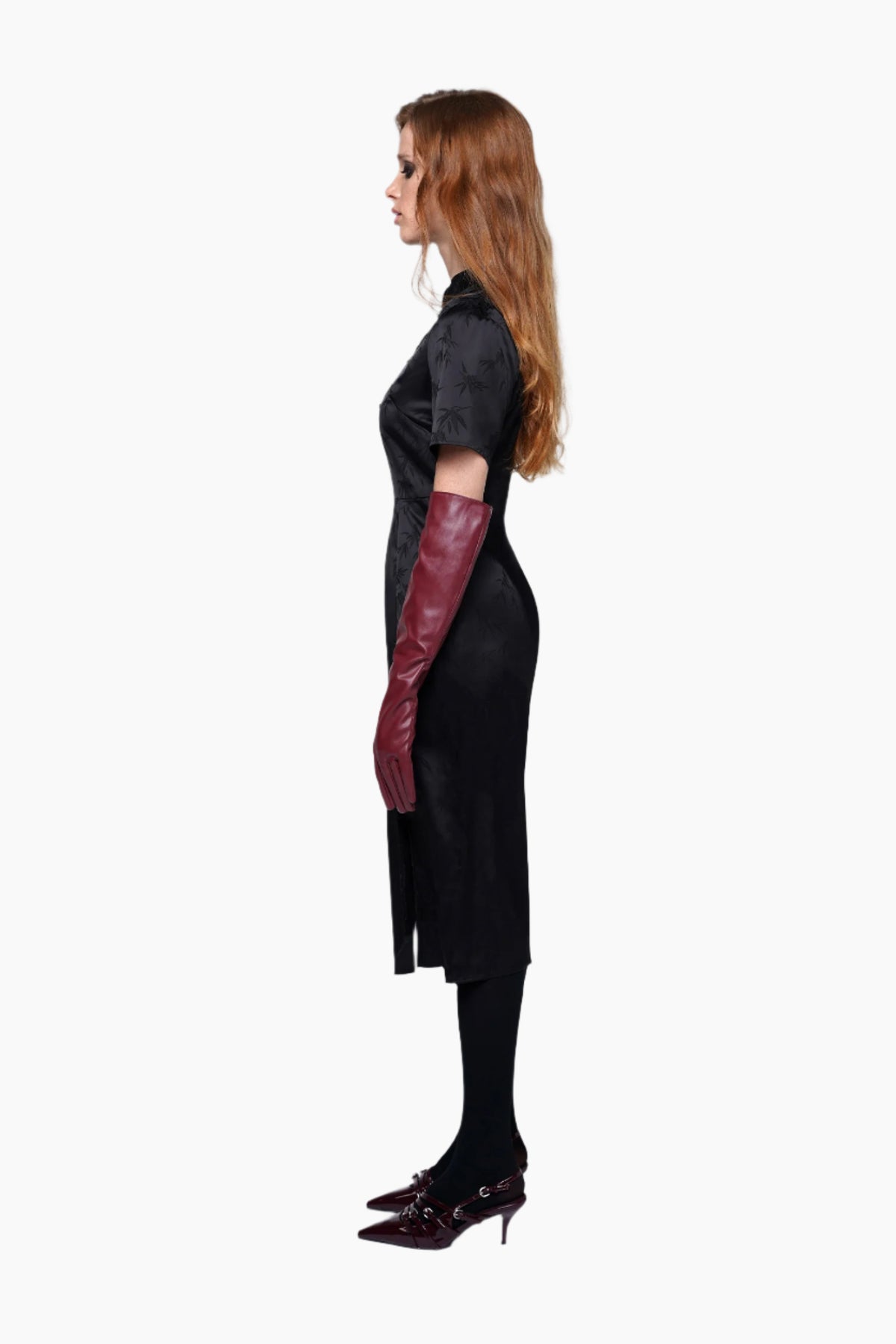 Woman wearing a black dress with cut-out design and red gloves 