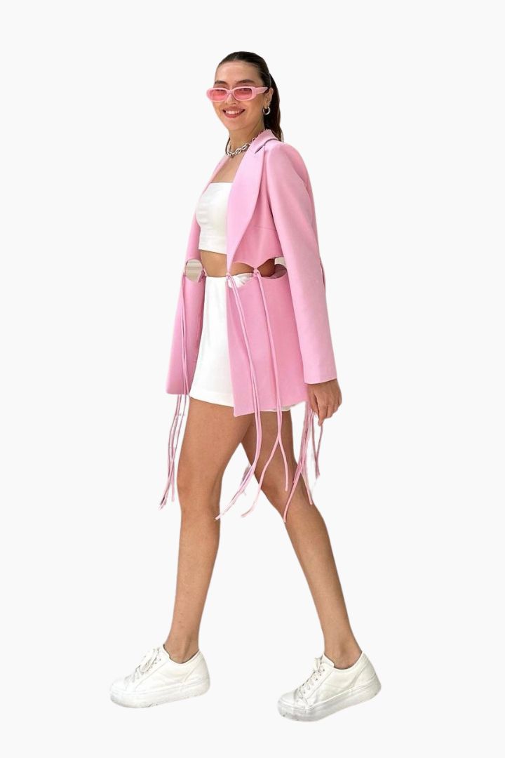 model wearing a pink blazer over a white outfit 