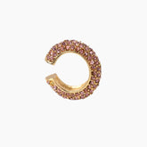 Gold and pink gemstone earring on a white background