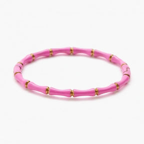 Pink beaded bracelet with gold accents on a white background