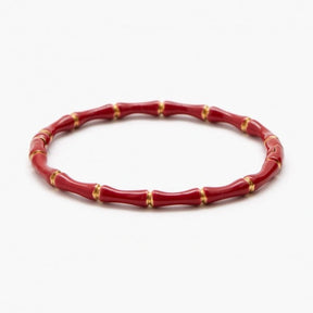 Red bracelet with gold accents on a white background