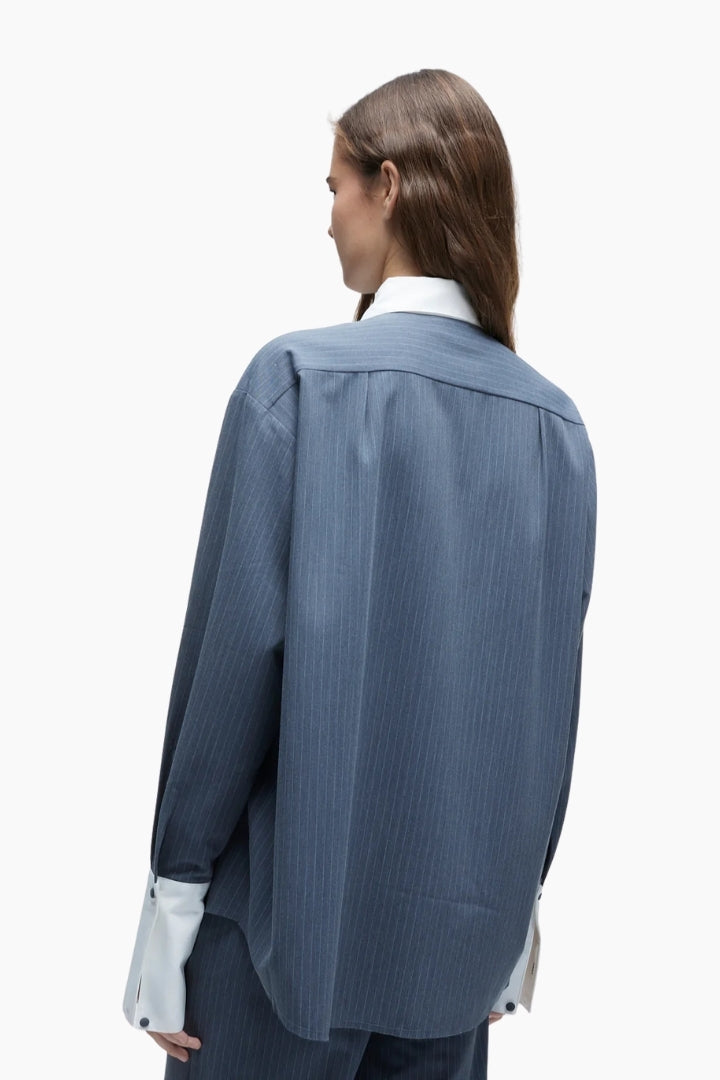 Woman wearing a blue pinstripe suit on a white background