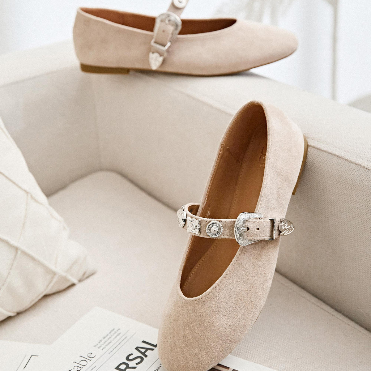 Pair of beige flat shoes with decorative straps 