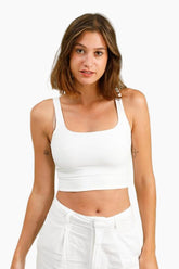 Woman wearing a white tank top and pants 