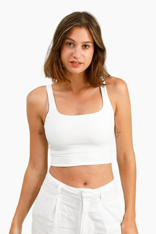 Woman wearing a white tank top and pants 