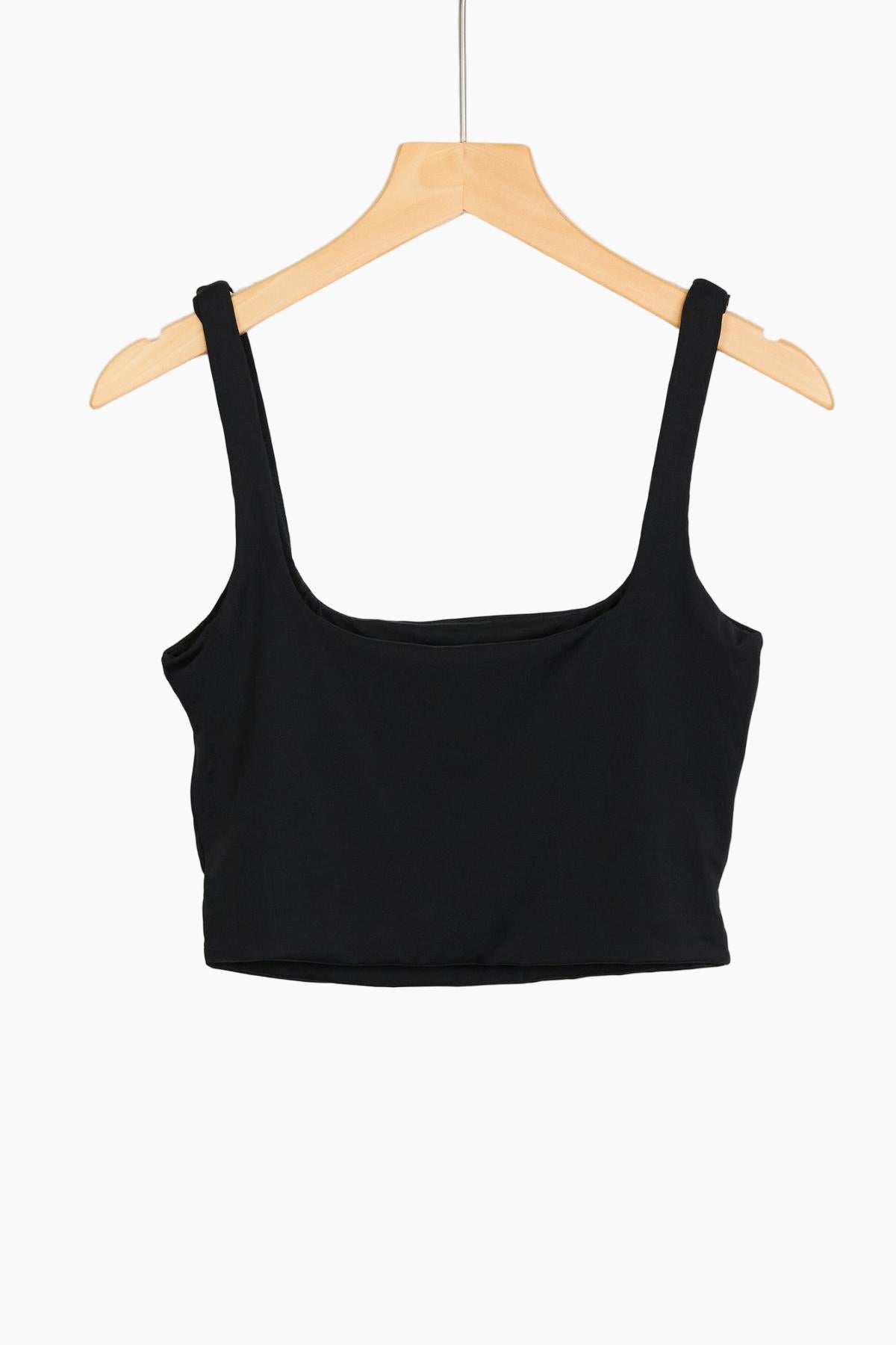 Black crop top on a wooden hanger 