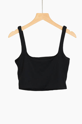 Black crop top on a wooden hanger 