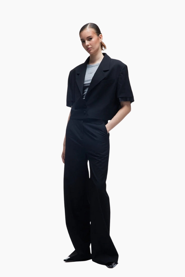 Person wearing a black outfit with a white background