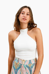 Woman wearing a white halter top and colorful patterned skirt 