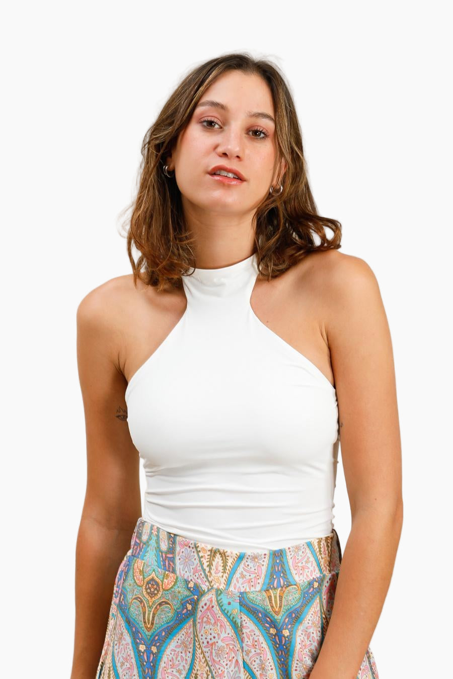 Woman wearing a white halter top and colorful patterned skirt 