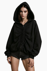 Person wearing a black hoodie and denim shorts 