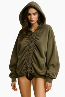 Woman wearing a green hoodie with ruched details 