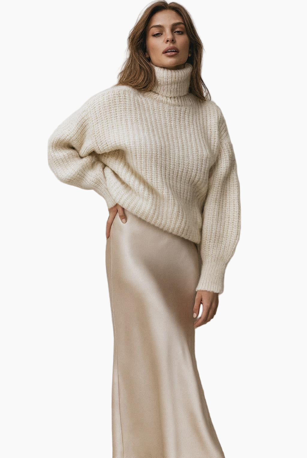 Woman wearing a cream ribbed sweater and beige satin skirt 