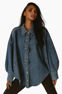 Woman wearing an oversized denim jacket on a white background