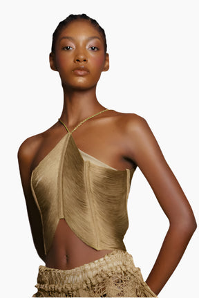 Woman wearing a gold halter top and skirt 