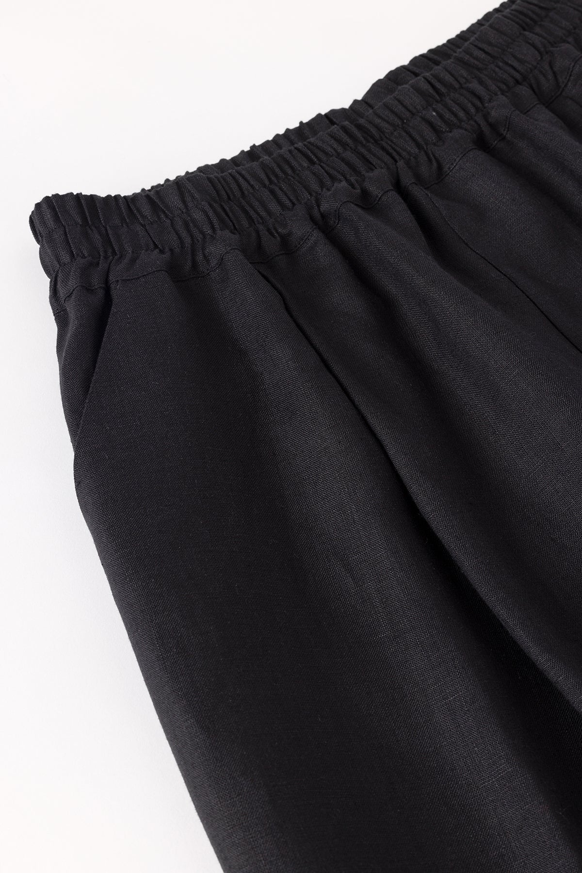 Black pants with an elastic waistband on a white background