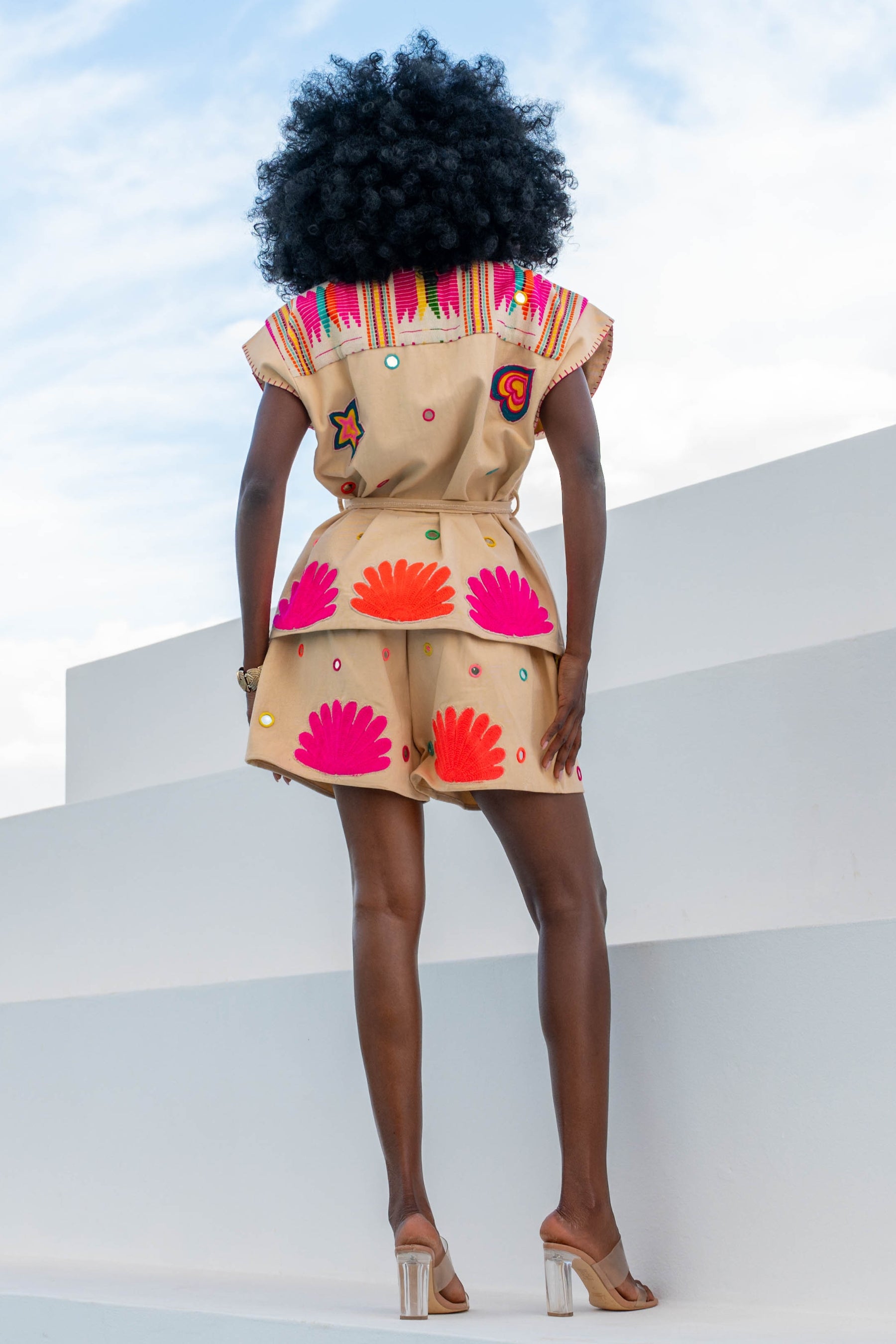 Person wearing a colorful outfit with shell patterns on a white background