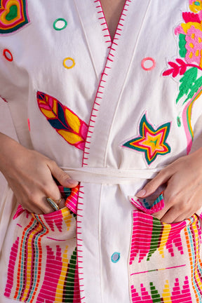 Colorful embroidered robe with star and feather designs on a white background