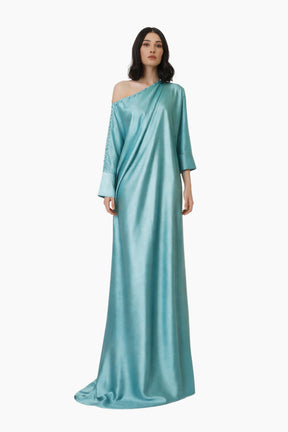Woman wearing a light blue one-shoulder gown on a white background