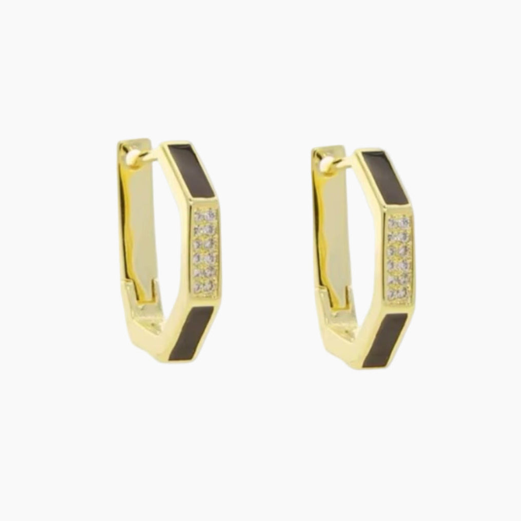 Gold hoop earrings with black accents and embedded stones on a white background
