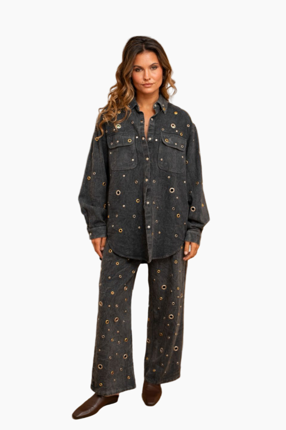 Woman wearing a dark denim outfit with decorative buttons