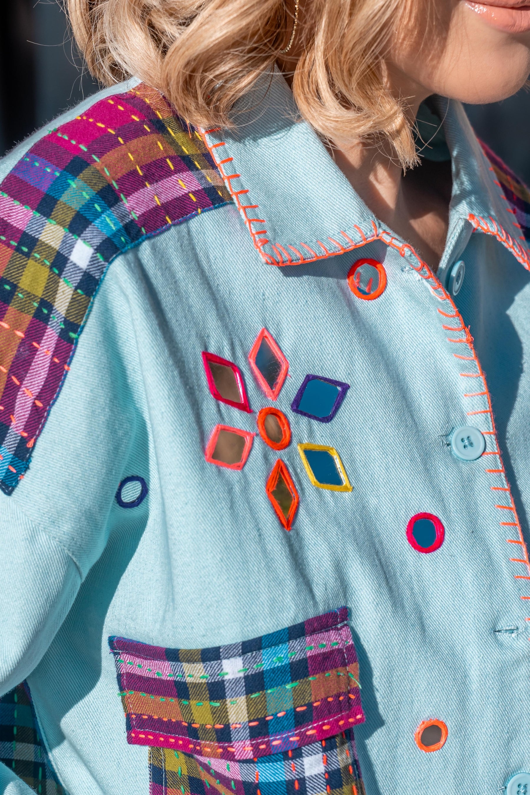 Close-up of a colorful jacket with geometric patterns and plaid accents.