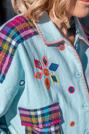 Close-up of a colorful jacket with geometric patterns and plaid accents.