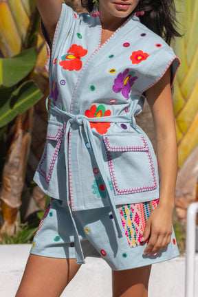 Woman wearing a colorful dress with floral patterns against a blurred natural background