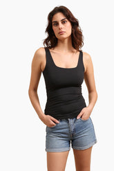 Woman wearing a black tank top and denim shorts 