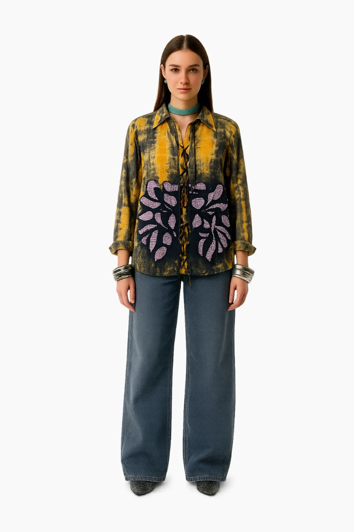 Woman wearing a patterned shirt and blue pants 
