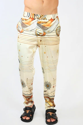 Beige pants with abstract pattern worn by a person on a white background