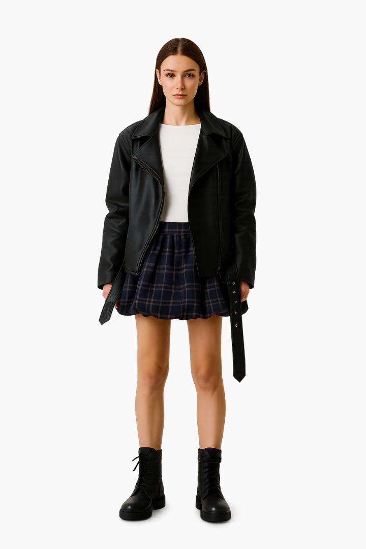 Person wearing a black leather jacket, white top, plaid skirt, and black boots 