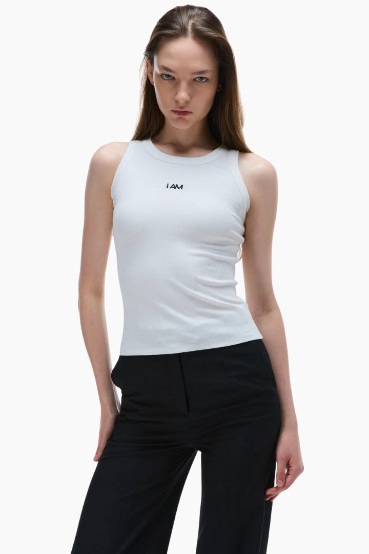 Woman wearing a white sleeveless top with a logo on a white background