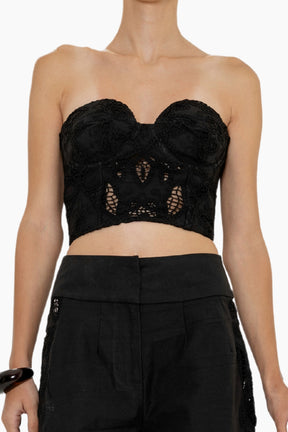 Strapless black bustier with structured cups and intricate floral cutwork.