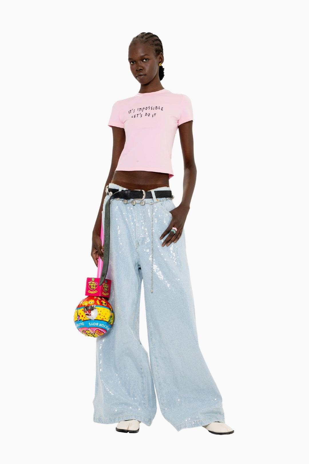 Model wearing a pink t-shirt and Light-wash, floor-length wide-leg jeans fully adorned with shimmering sequins for a statement finish.
