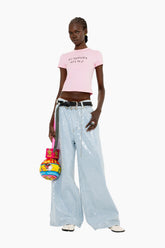 Model wearing a pink t-shirt and Light-wash, floor-length wide-leg jeans fully adorned with shimmering sequins for a statement finish.