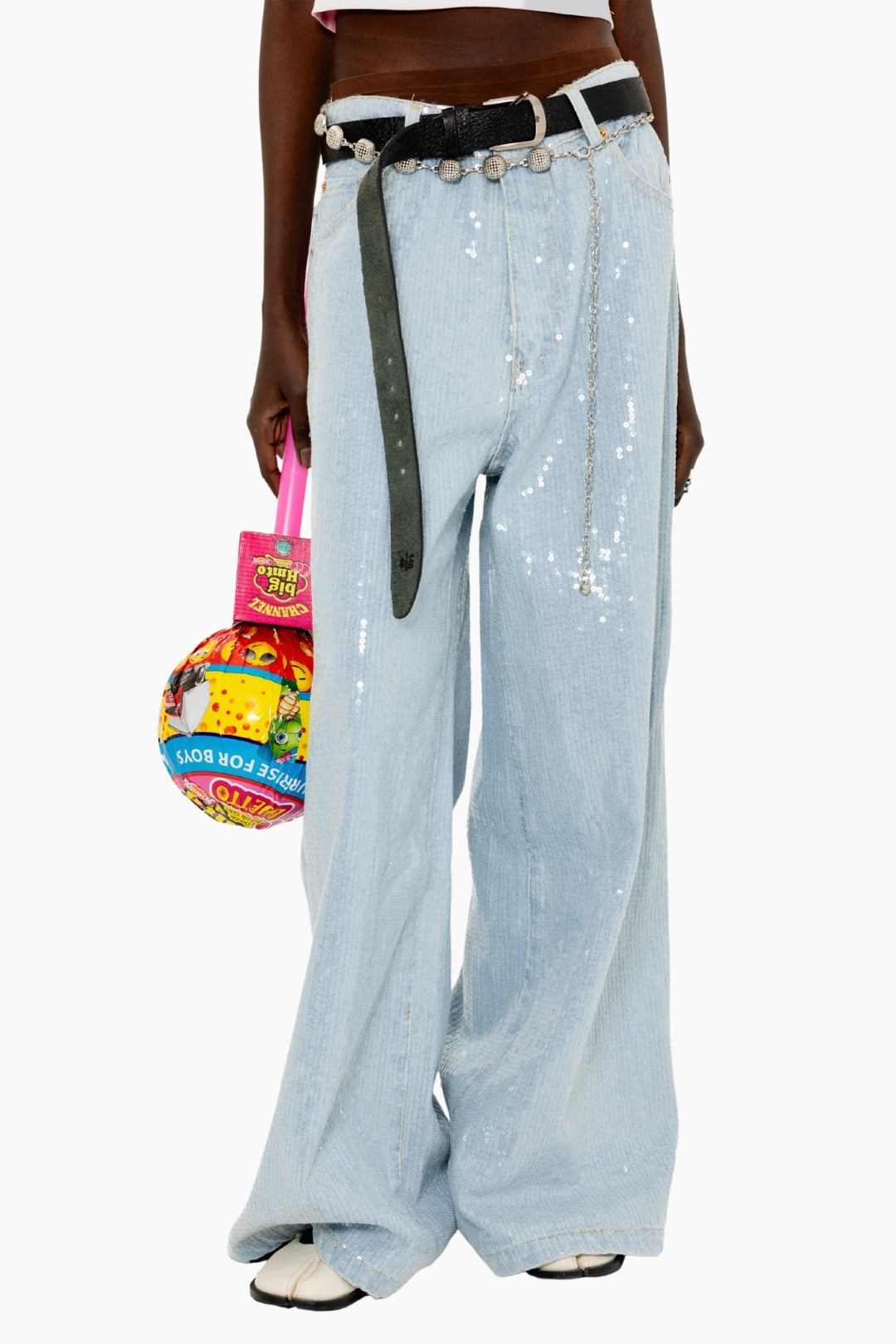 Person wearing light blue sequin pants with a colorful bag